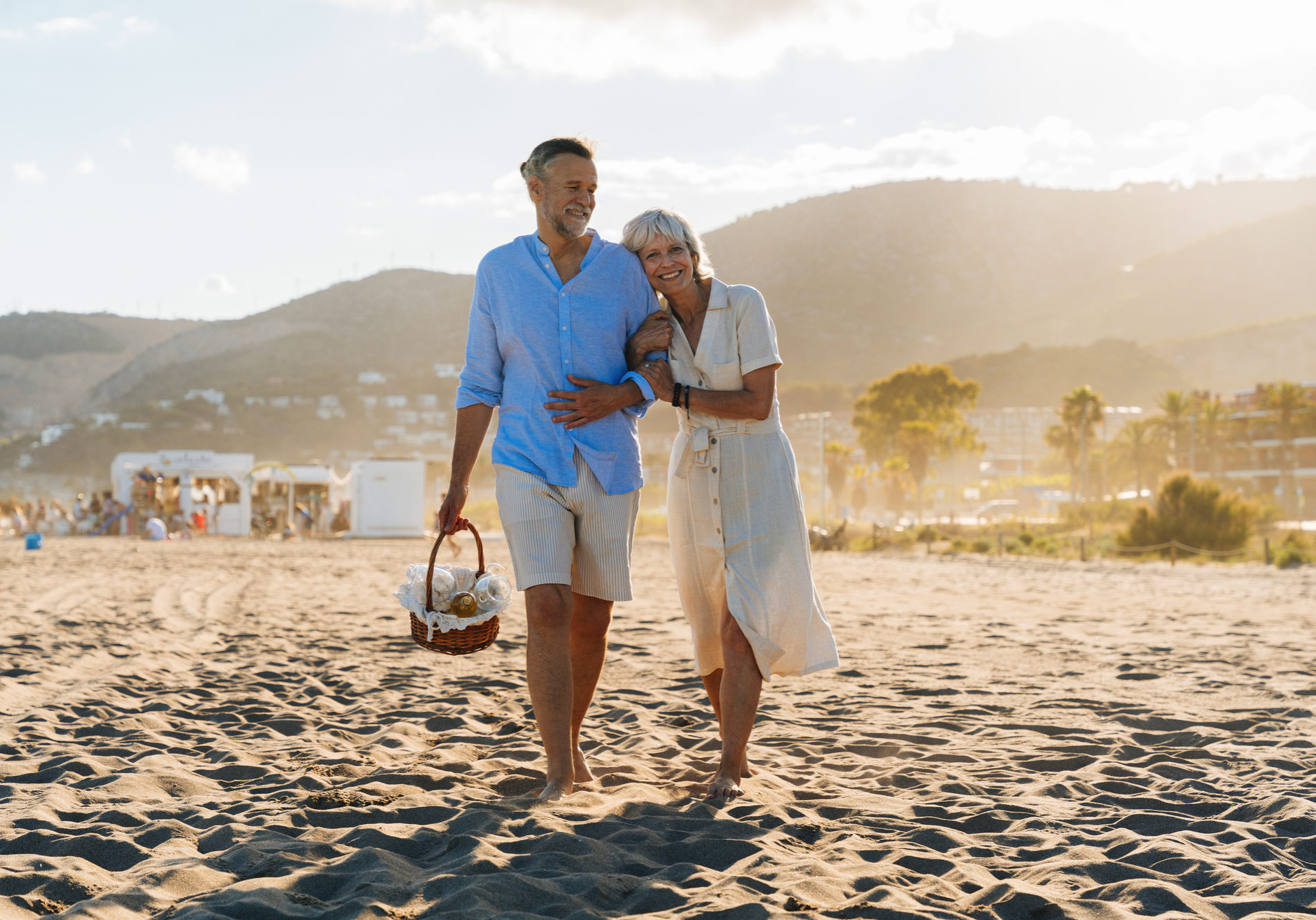Beautiful happy senior couple dating at the seaside during summertime - Mature married couple in love bonding outdoors at the beach, concepts about elderly lifestyle, relationship and quality of life